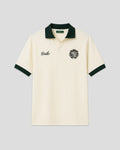Cream-colored émilio pique shirt with green trim on a light gray background